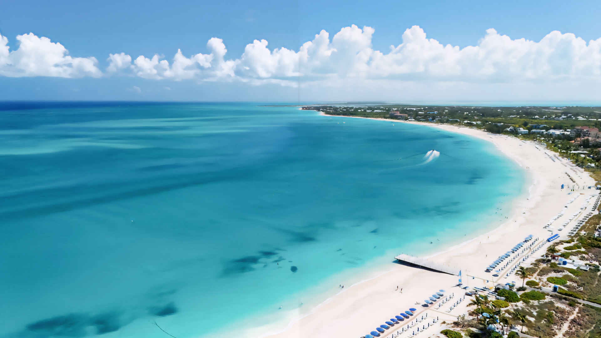 a beach with blue water and buildings