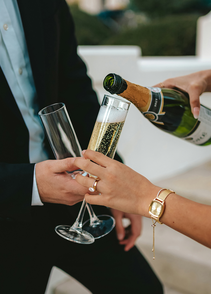 a person pouring champagne into a glass