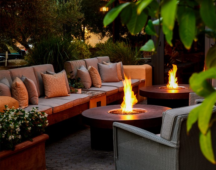 a fire pit and couches with pillows on a patio