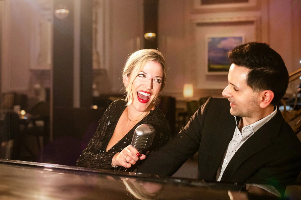 a man and woman singing into a microphone