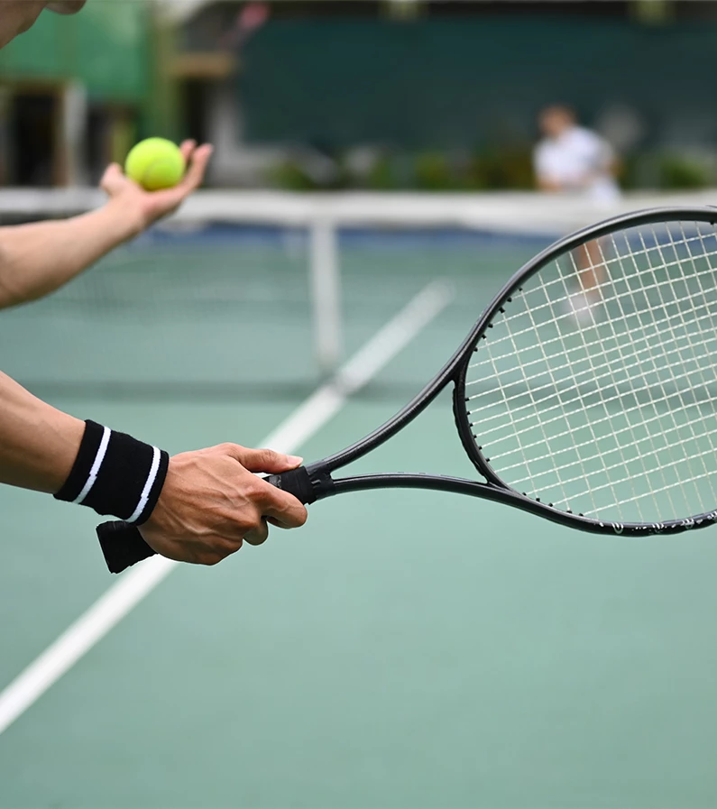 a person holding a tennis racket and a ball