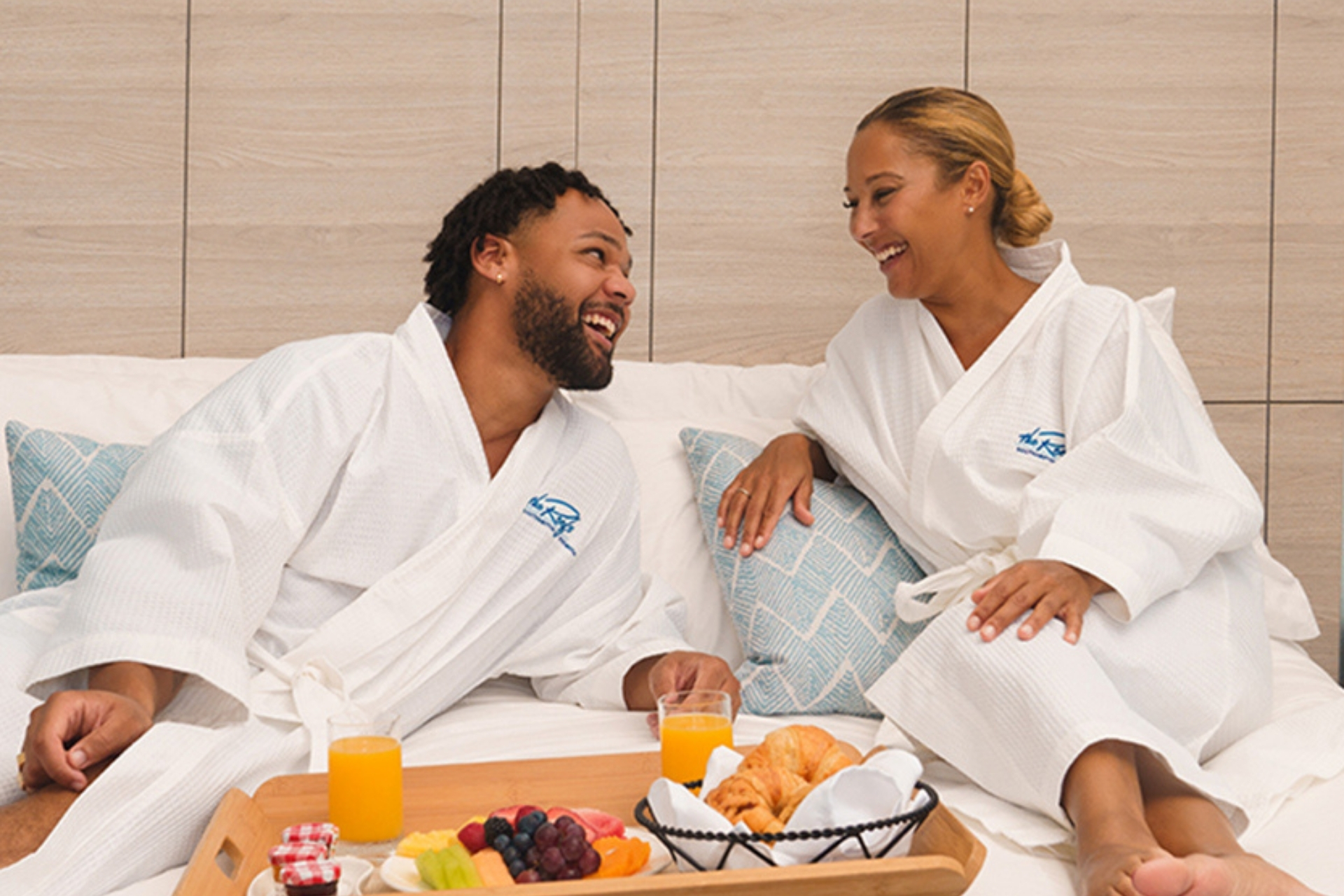 a man and woman in white robes sitting on a bed