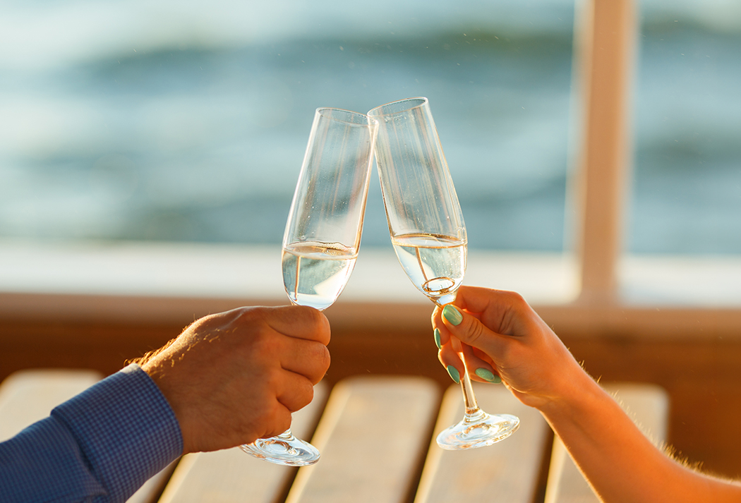 a pair of hands holding wine glasses
