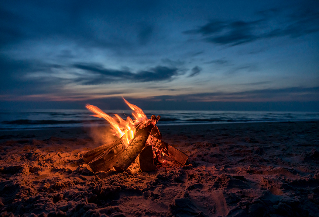 a campfire on a beach