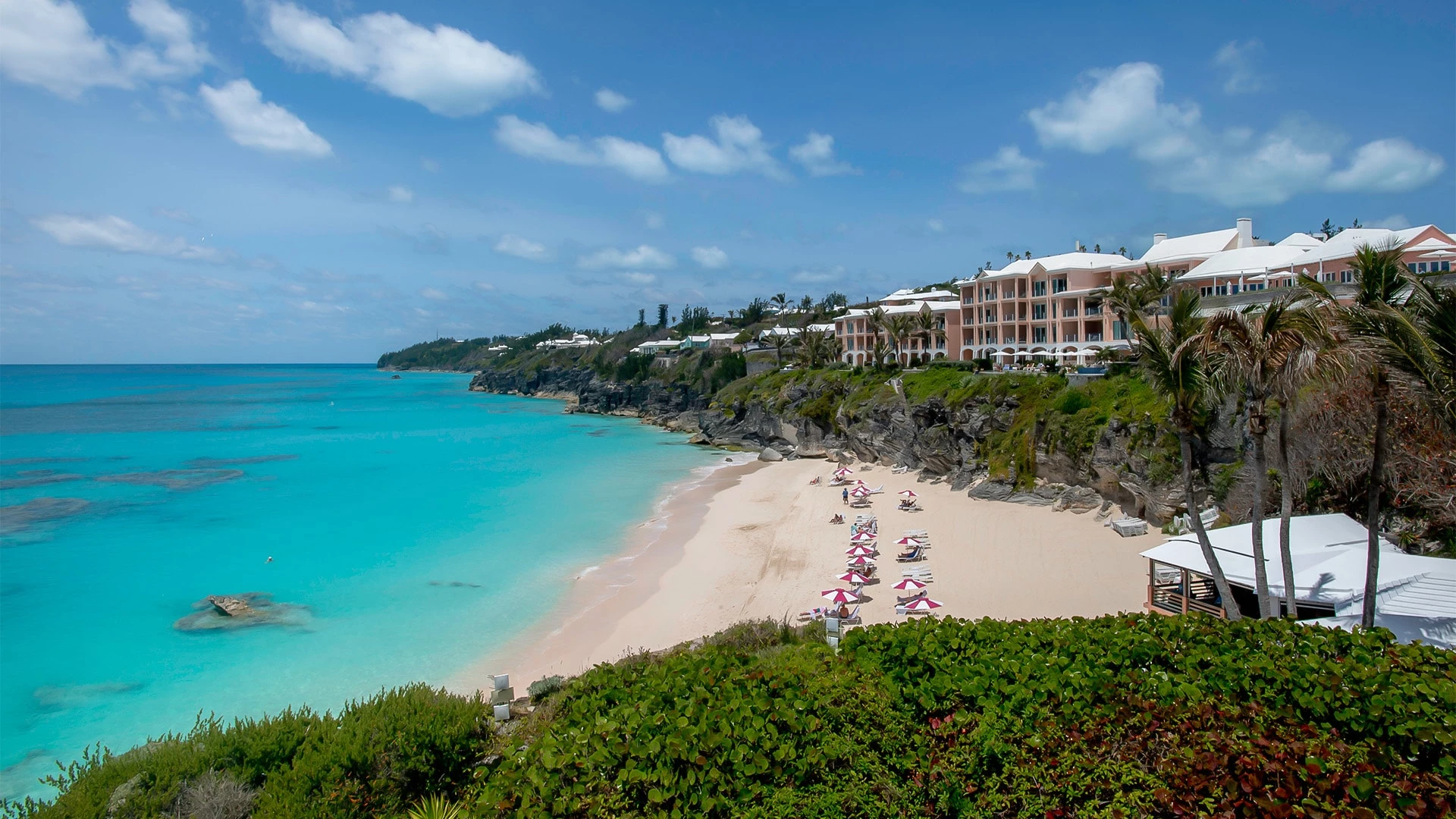 a beach with a building and chairs on it