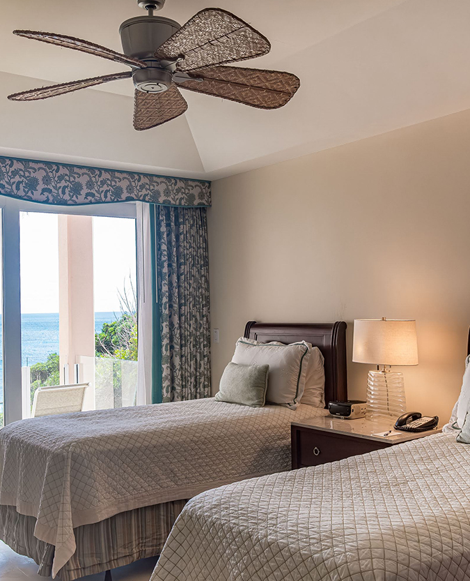 a room with two beds and a ceiling fan