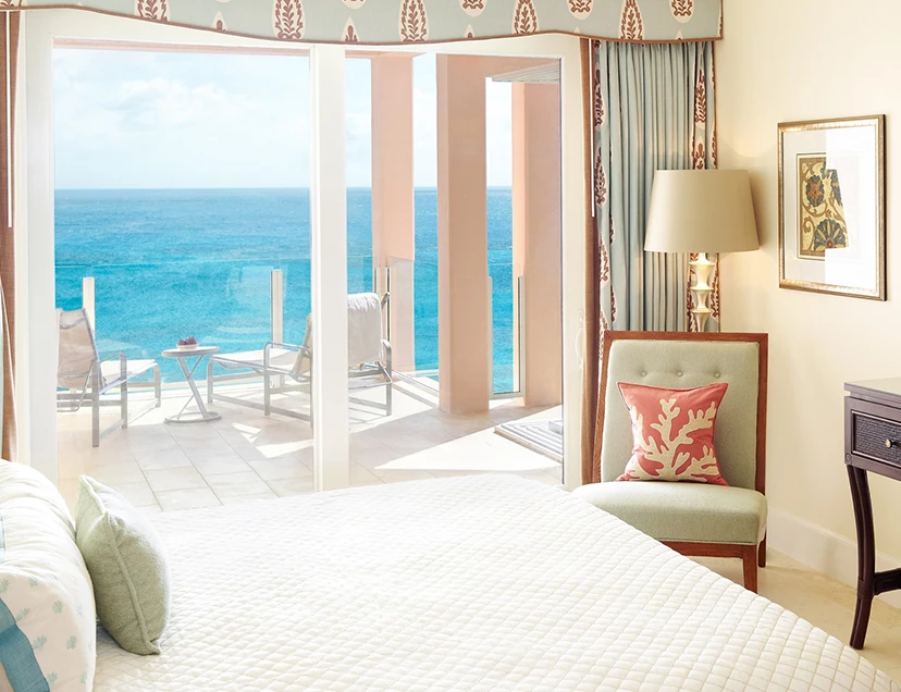 a bedroom with a large window overlooking the ocean