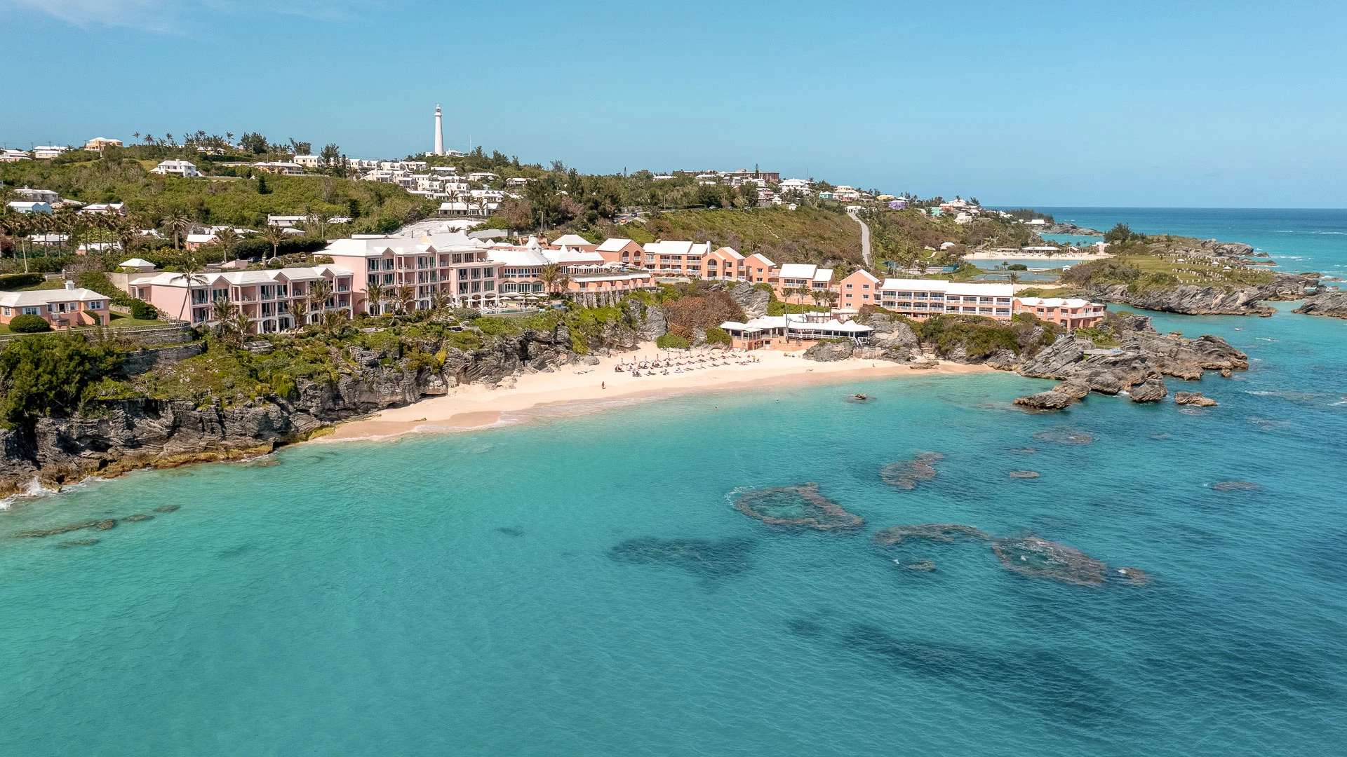 a beach with buildings and a body of water