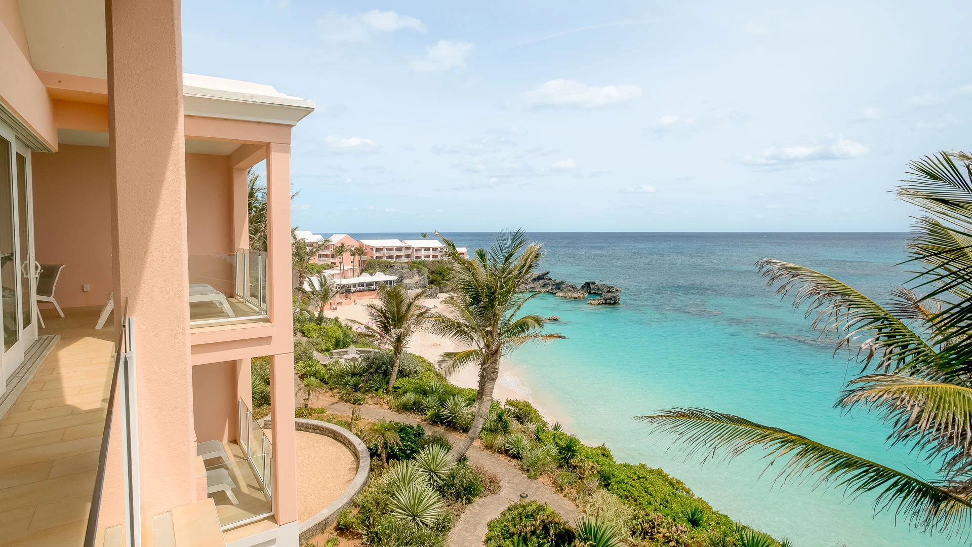 a building with a beach and palm trees