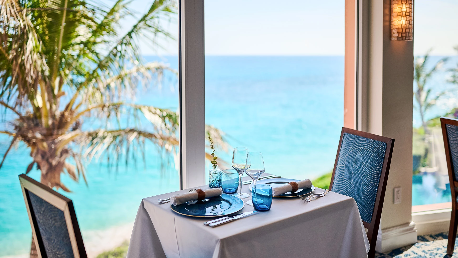 a table set for a dinner with a view of the ocean