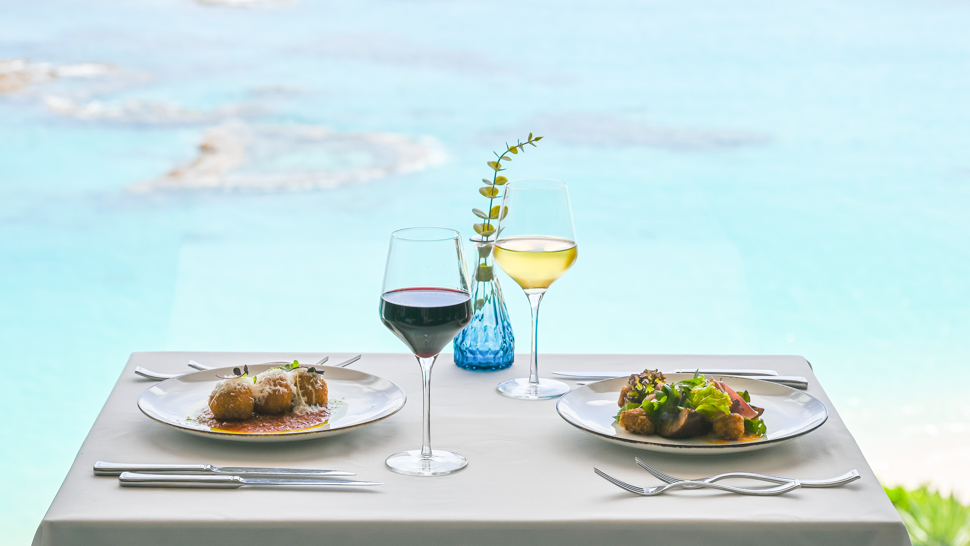 a table with plates of food and wine glasses