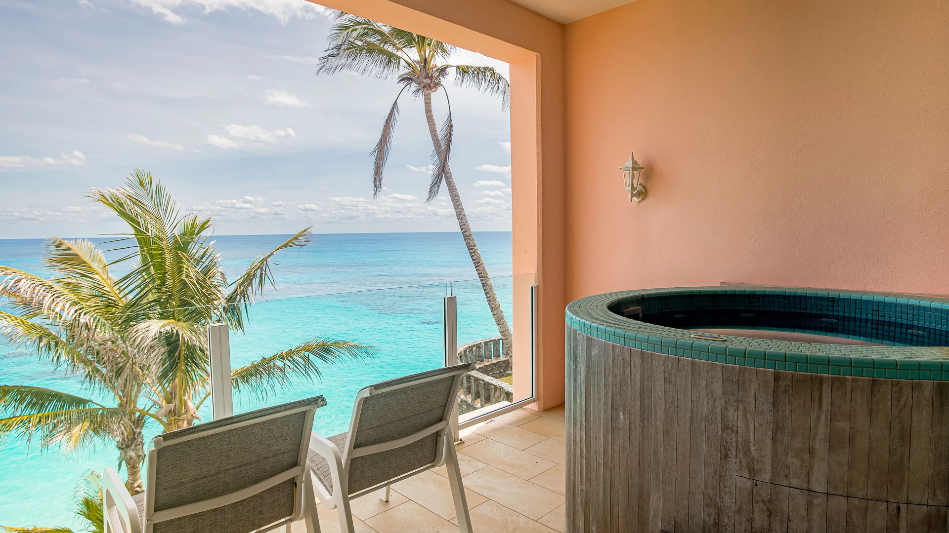 a hot tub with chairs overlooking the ocean