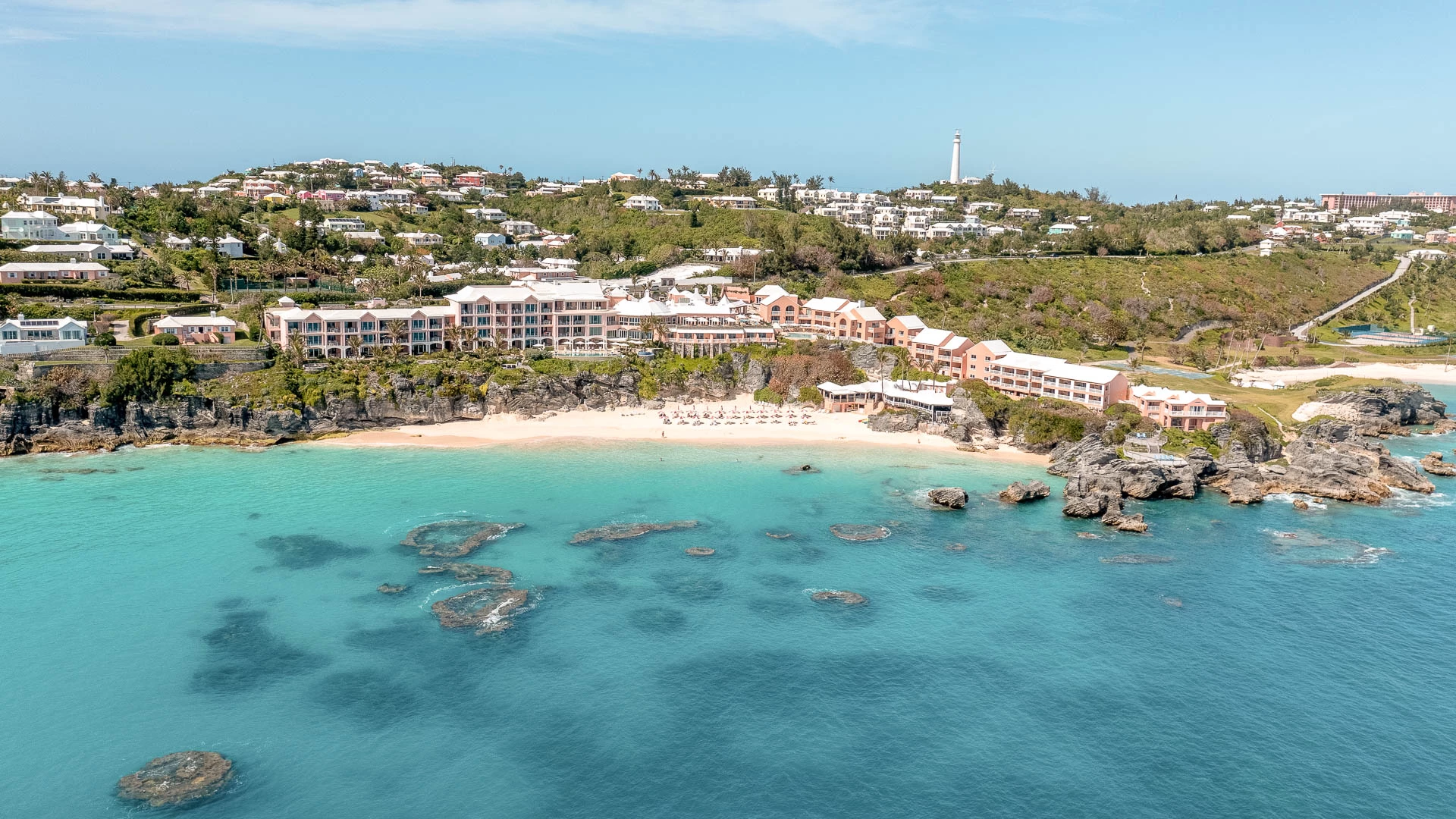 a beach with buildings and a lighthouse
