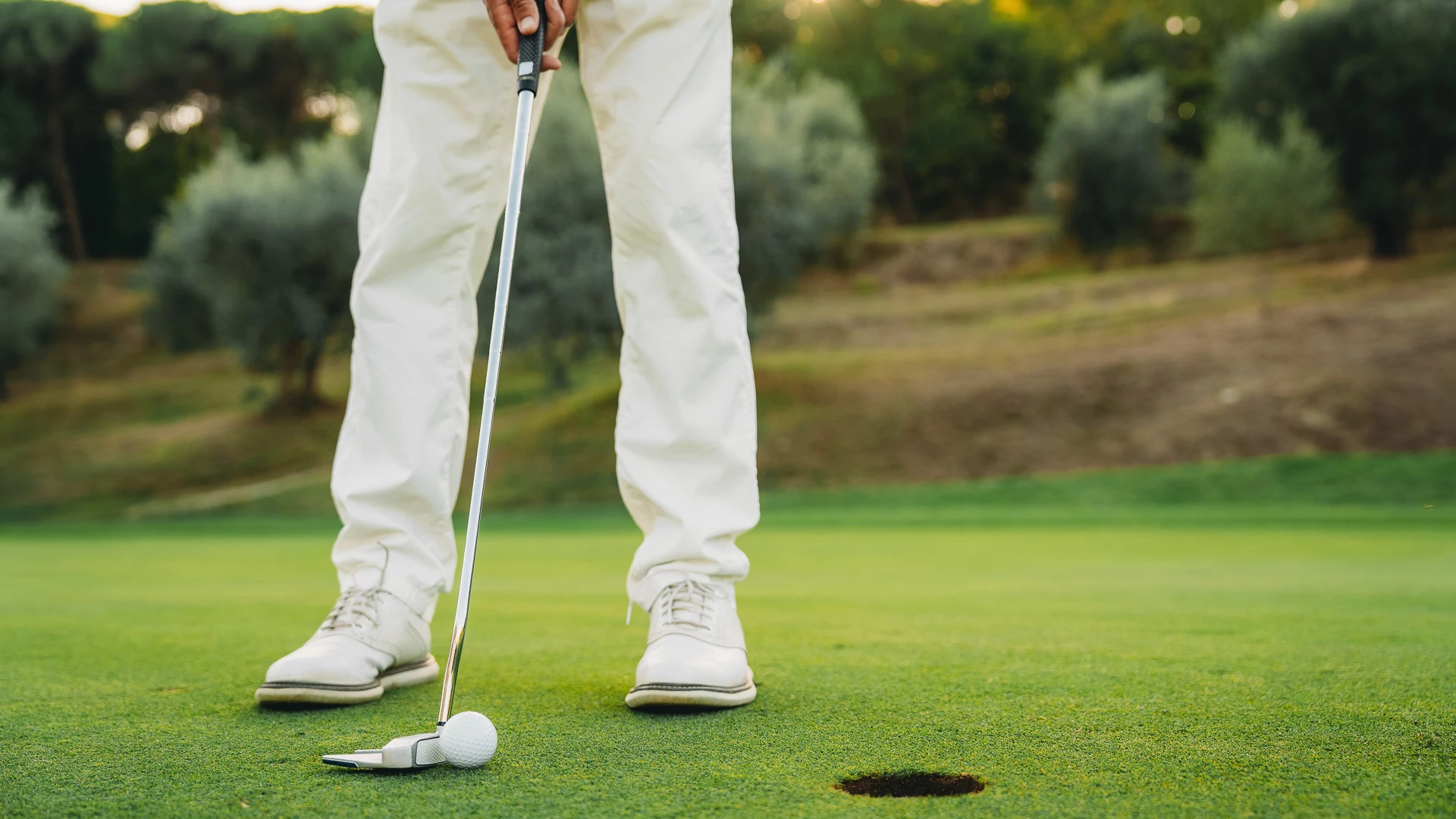 a person putting a golf ball on a golf course