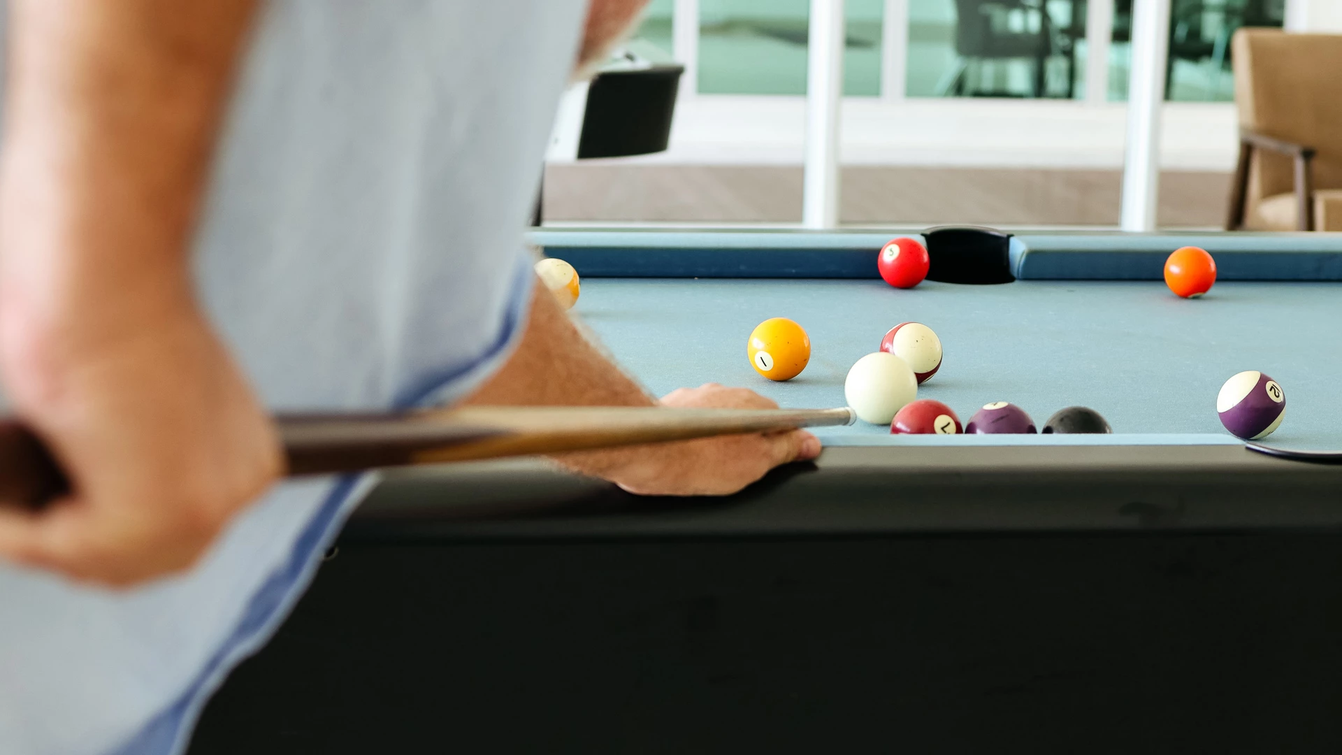 a man playing pool with a stick