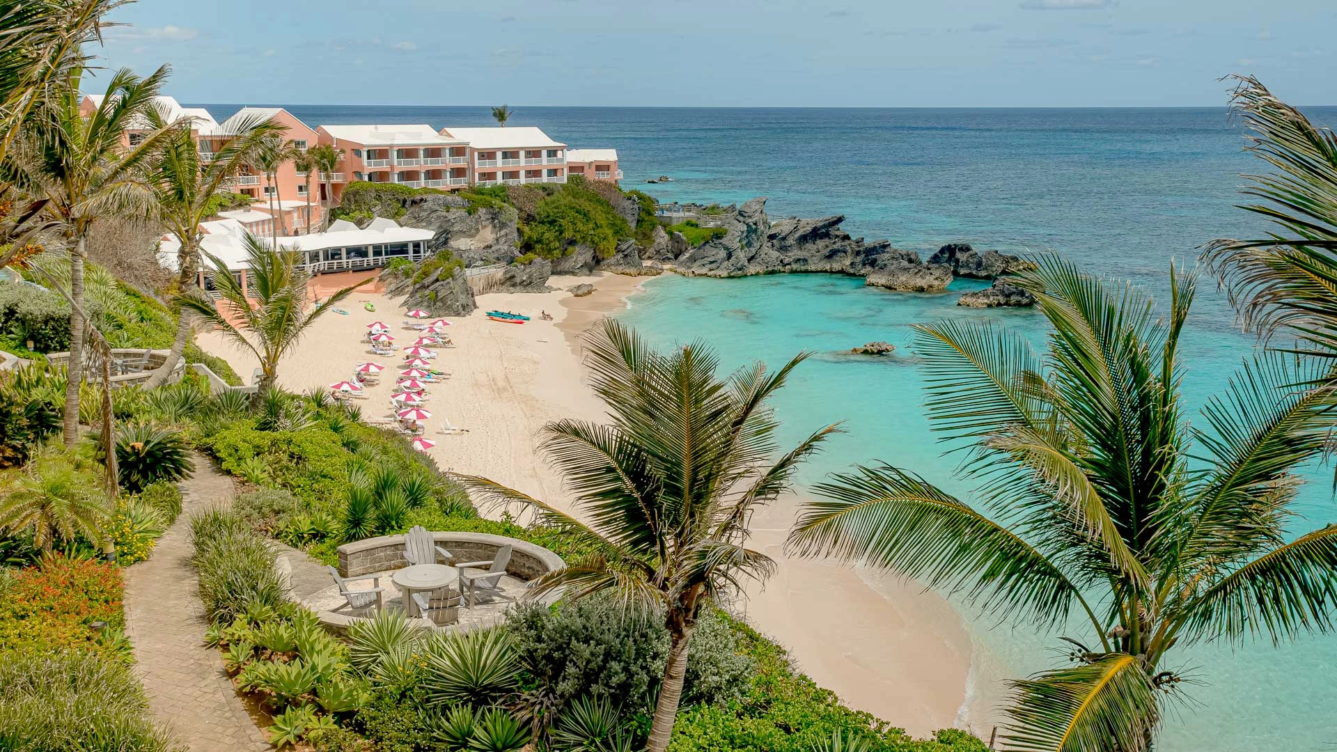 a beach with a hotel and palm trees