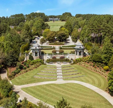 a large lawn with benches and a building in the middle