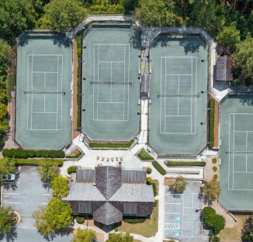 tennis courts with trees around them