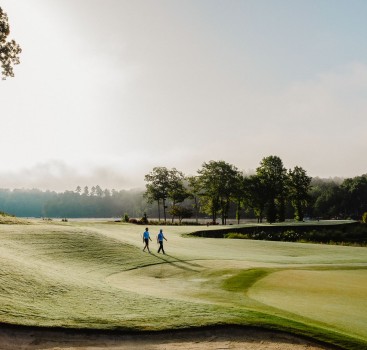 a group of people walking on a golf course