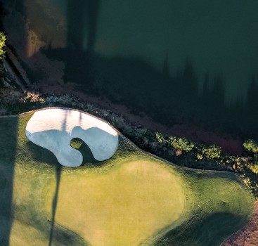 a golf course with a white sand trap