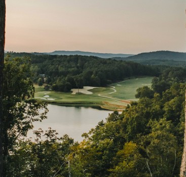 a golf course with a lake and trees