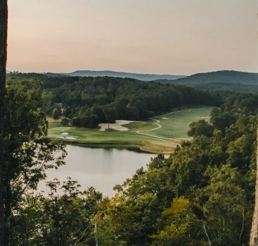 a golf course with a lake and trees