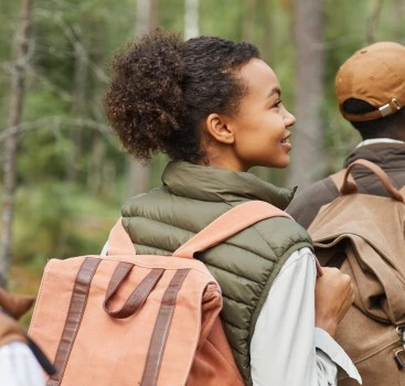a woman with backpacks looking away from a man