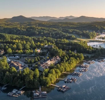 a aerial view of a lake with a group of houses and trees