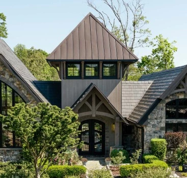a house with a stone roof and a brown roof