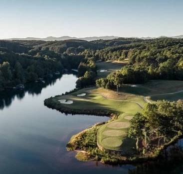 a golf course with a river and trees