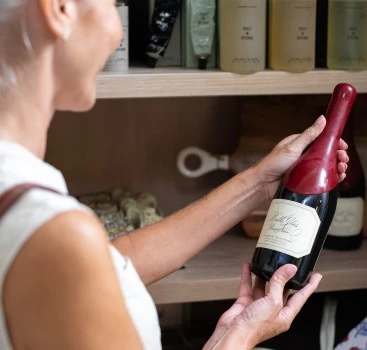 a woman holding a bottle of wine