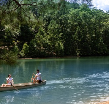 a man and woman in a canoe on a lake