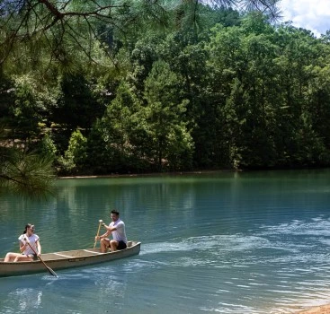 a man and woman in a canoe on a lake