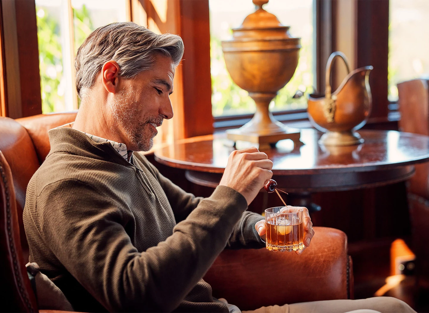 a man sitting in a chair pouring liquid into a glass