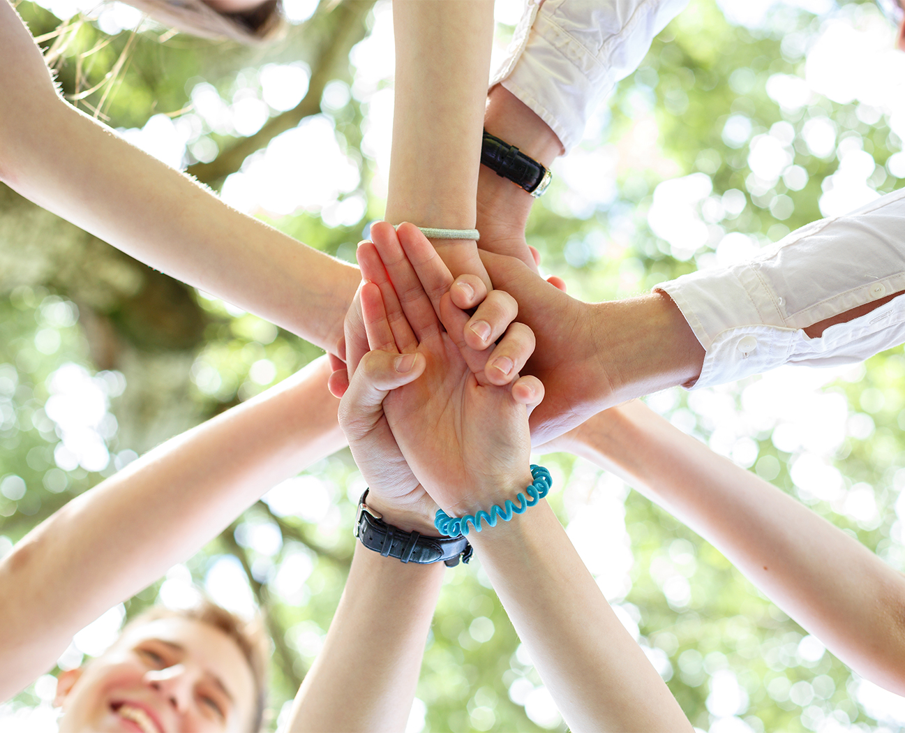a group of people putting their hands together