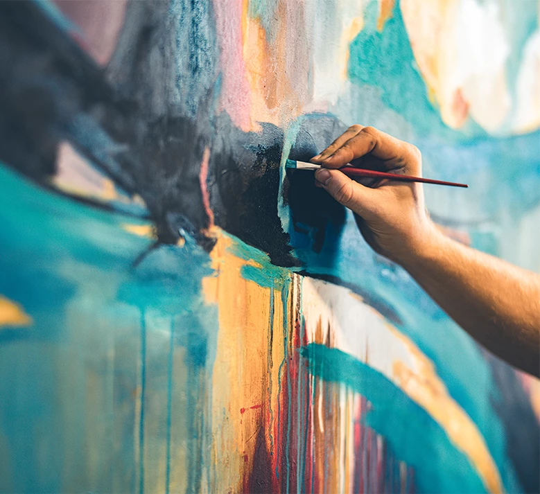 a hand holding a brush painting a wall