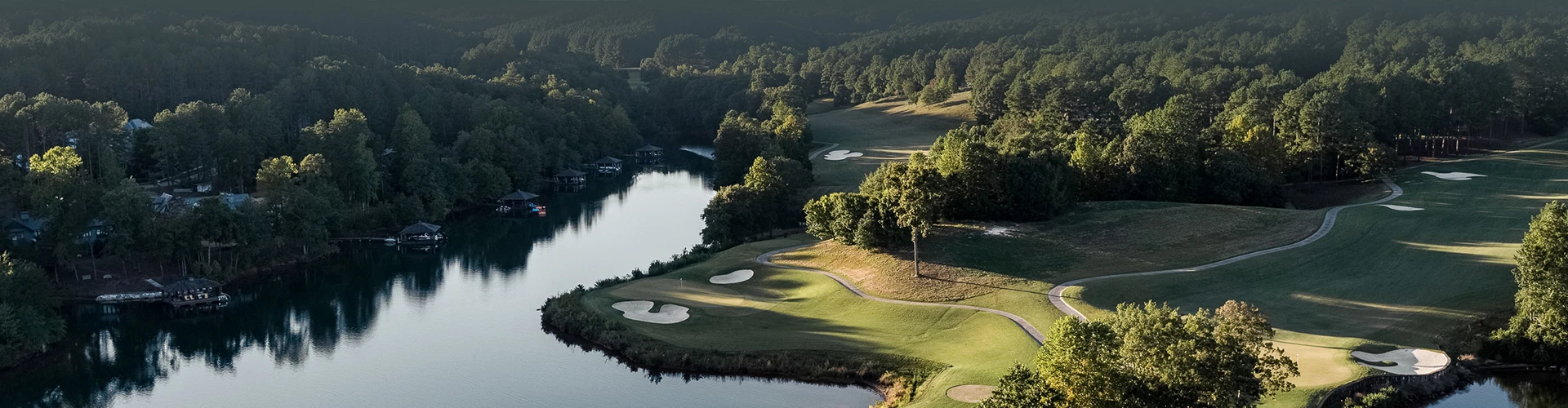 a golf course with a river and trees