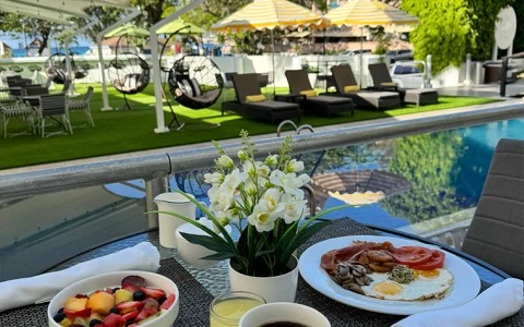 a breakfast on a table with a pool in the background