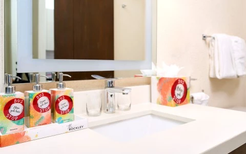 a bathroom sink with soap dispensers and a mirror