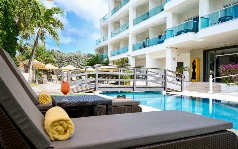 a pool with a glass of liquid and a cocktail next to it