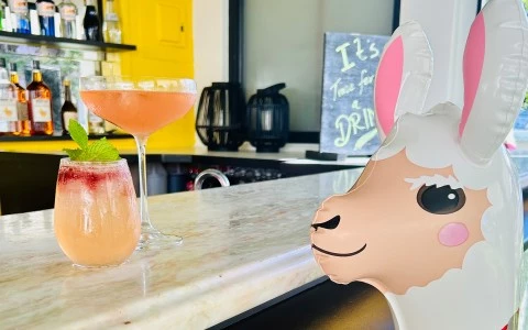 a llama balloon and a drink on a counter