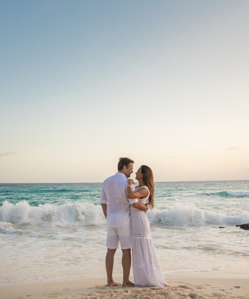 a man and woman standing on a beach