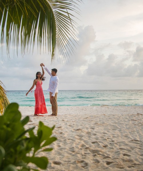 a man and woman dancing on a beach