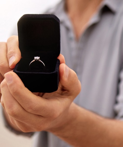 a person holding a box with a ring