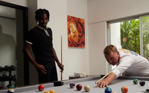 a man playing pool with a stick