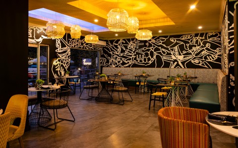 a room with tables and chairs and a wall with lights