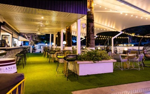 a covered patio with tables and chairs