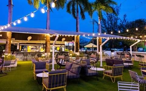 a patio area with chairs and tables and lights