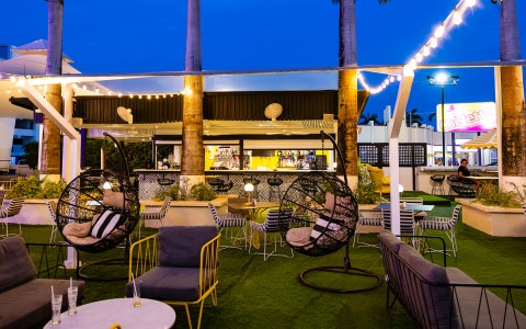 a patio with chairs and tables and a bar
