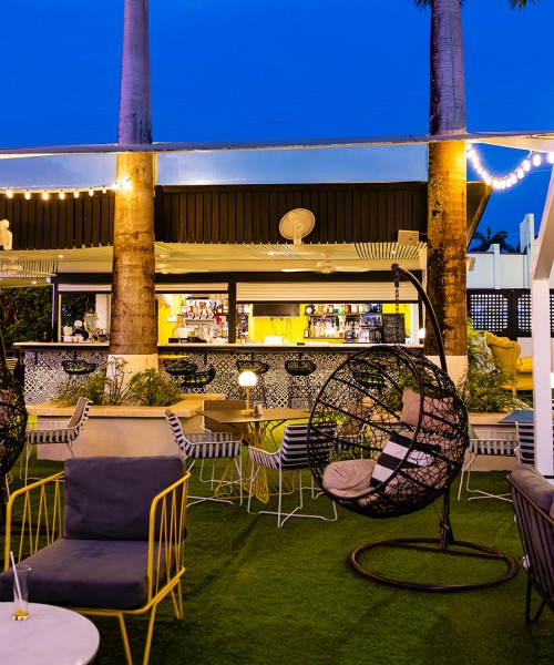 a patio with chairs and tables and a bar